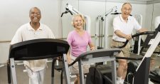 Is Sitting Too Much Bad for Your Brain? Picture of an elderly black male, an elderly caucasian female and an elderly caucasian male all walking on tread mills.